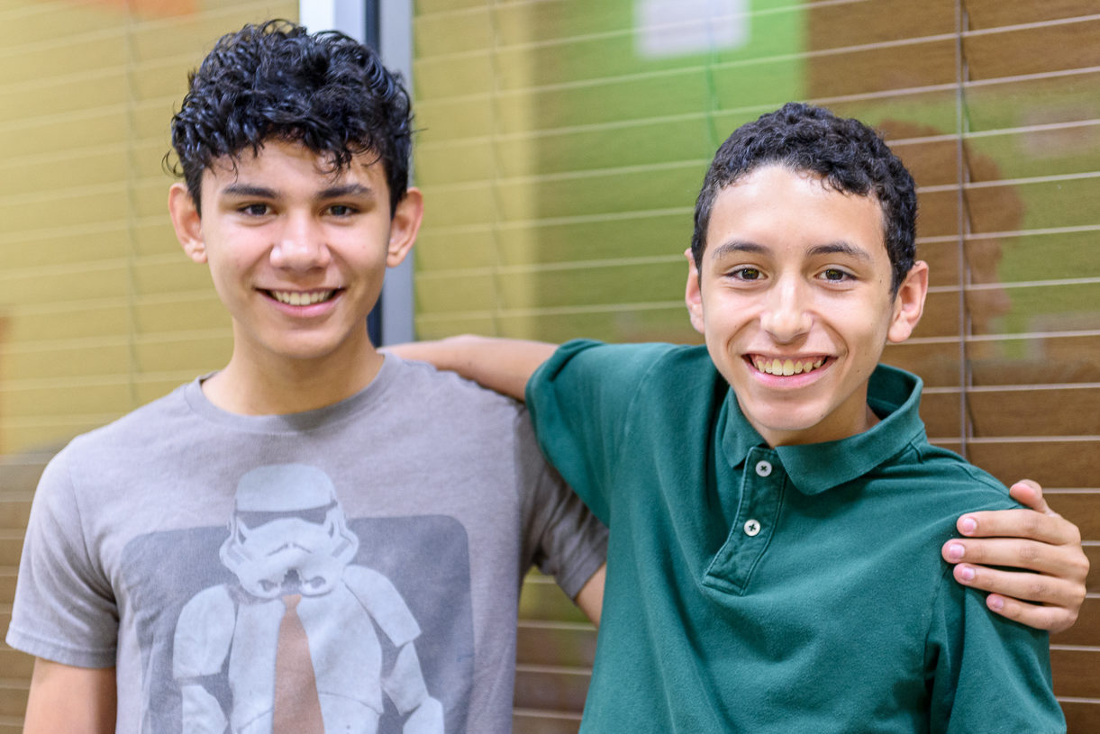 Two teenage boys smiling.