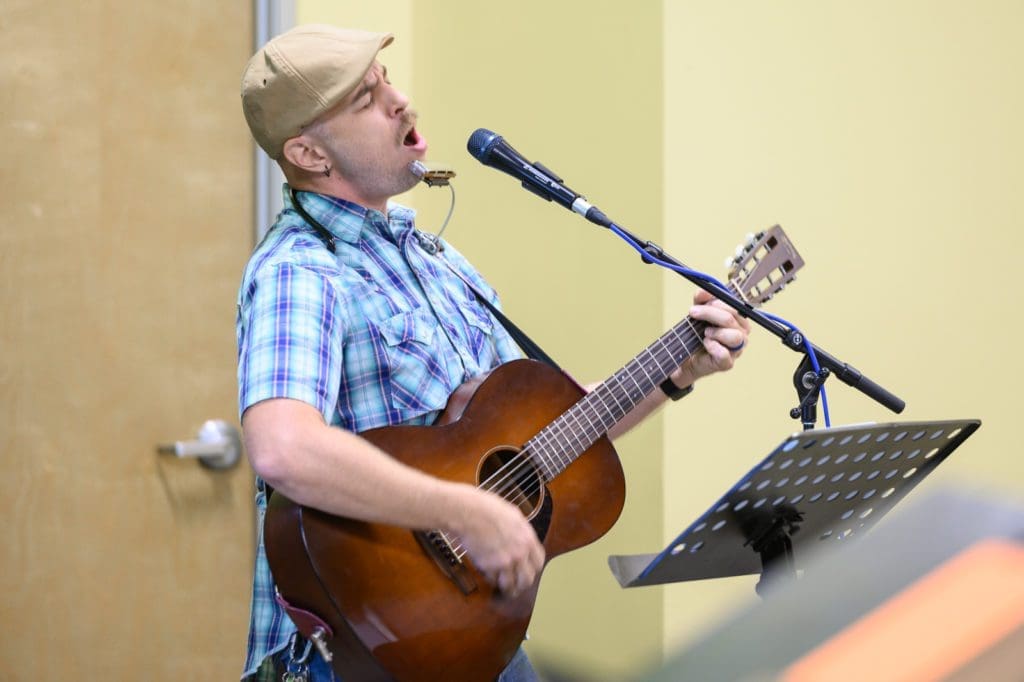 Worship leader playing guitar and singing.